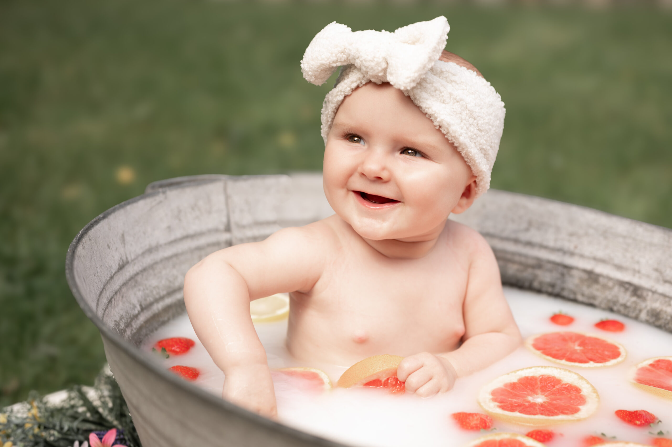 een baby in een bak met melk en stukjes fruit